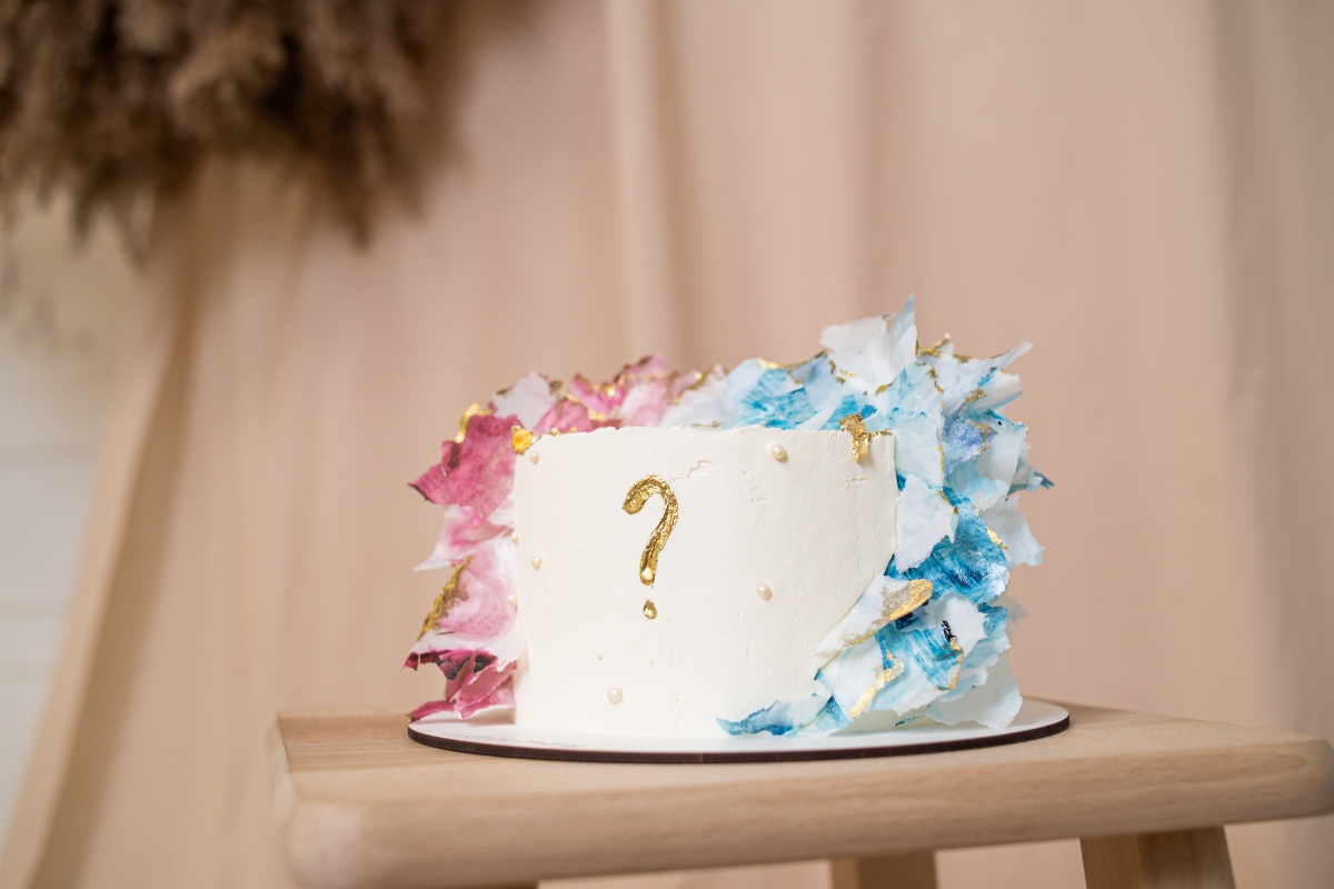 prikaz torte sa roze-plavim šlagom i upitnikom, torta za otkrivanje pola